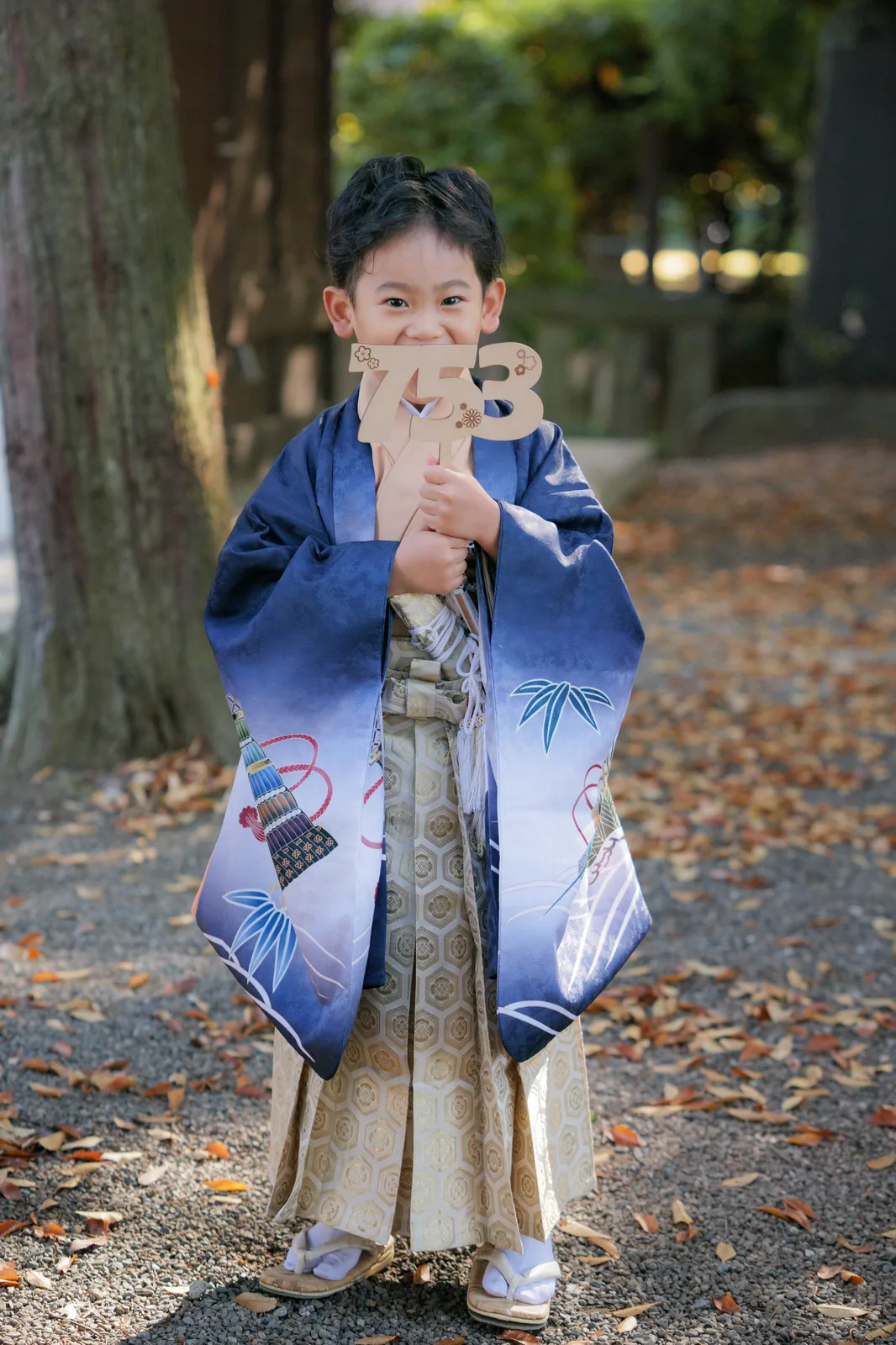 「753」の木札を持ってはにかむ袴姿の5歳の男の子