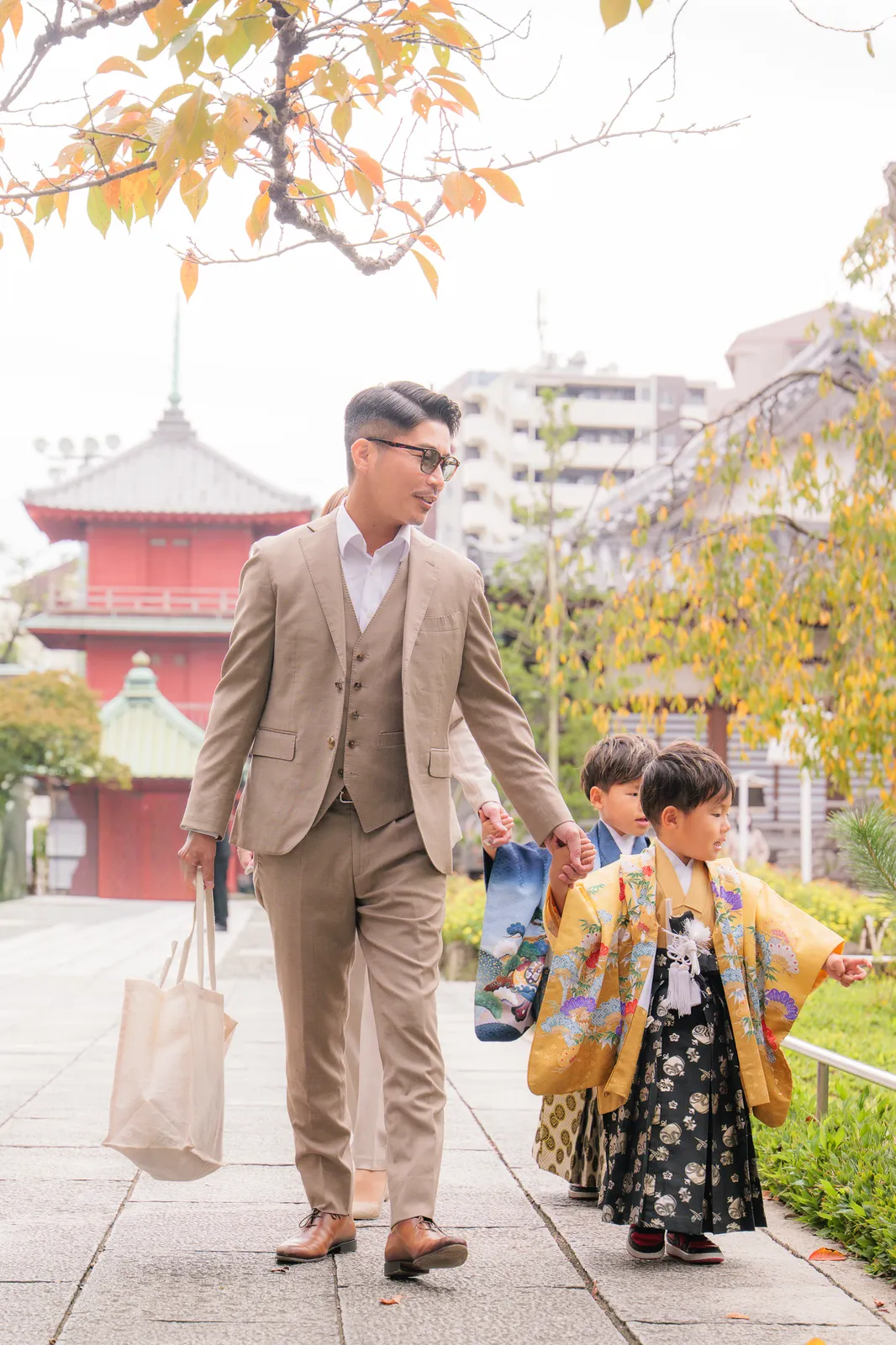 パパと手をつないで参道を歩く七五三の兄弟